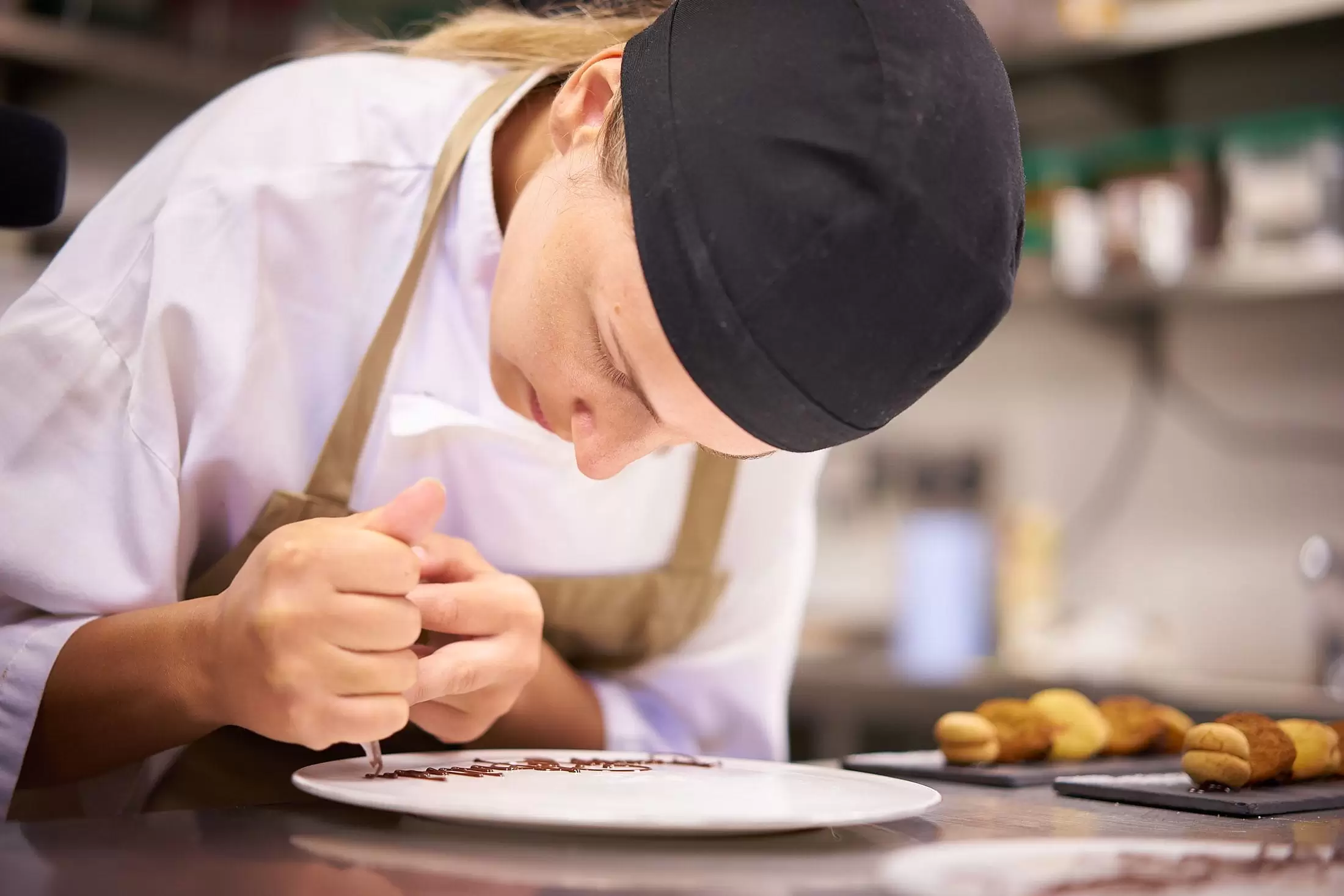 A Hari employee in the pastry kitchen creating a personalised dessert for a guest