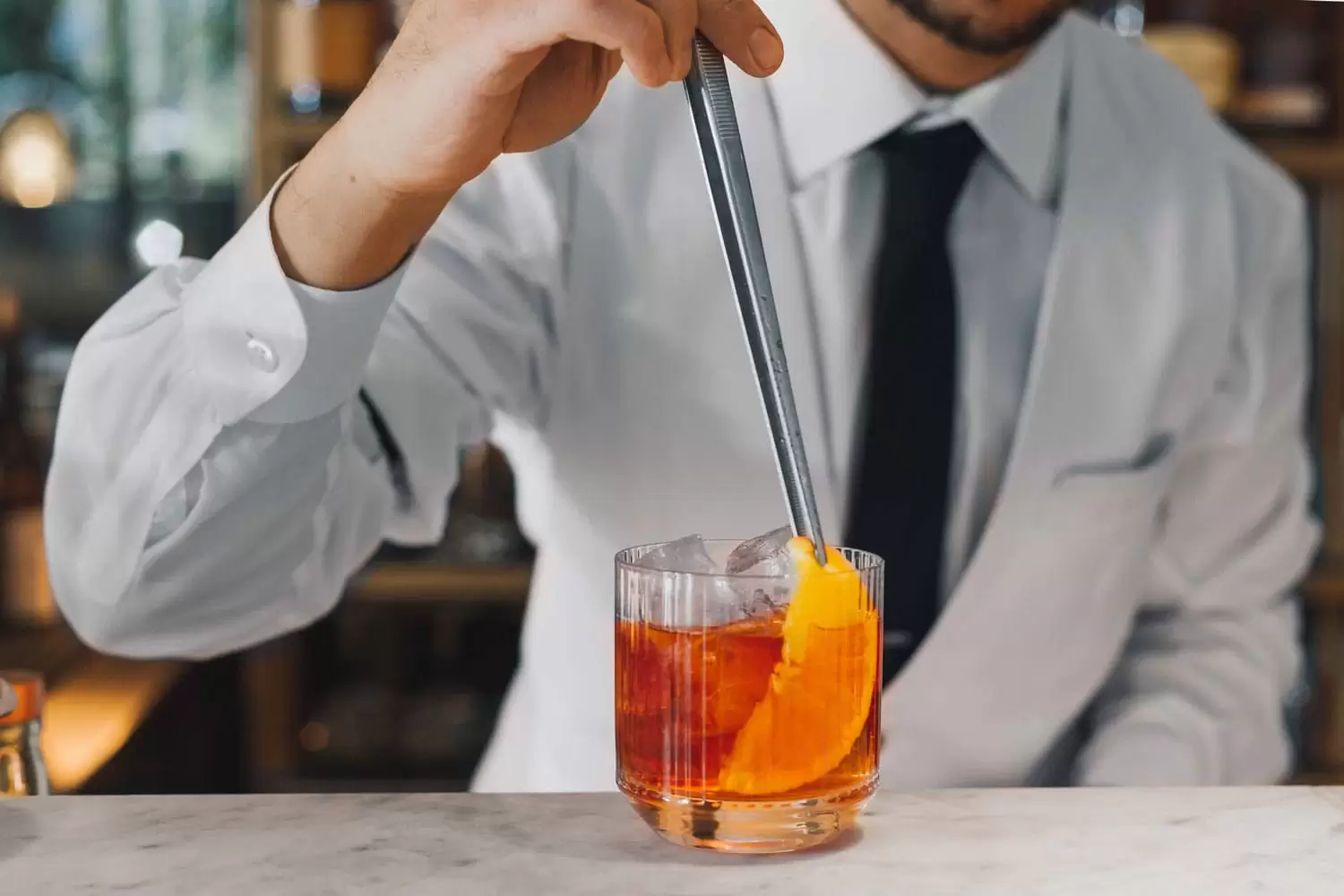 A bratender mixing a Negroni cocktail on the bar of il Pampero