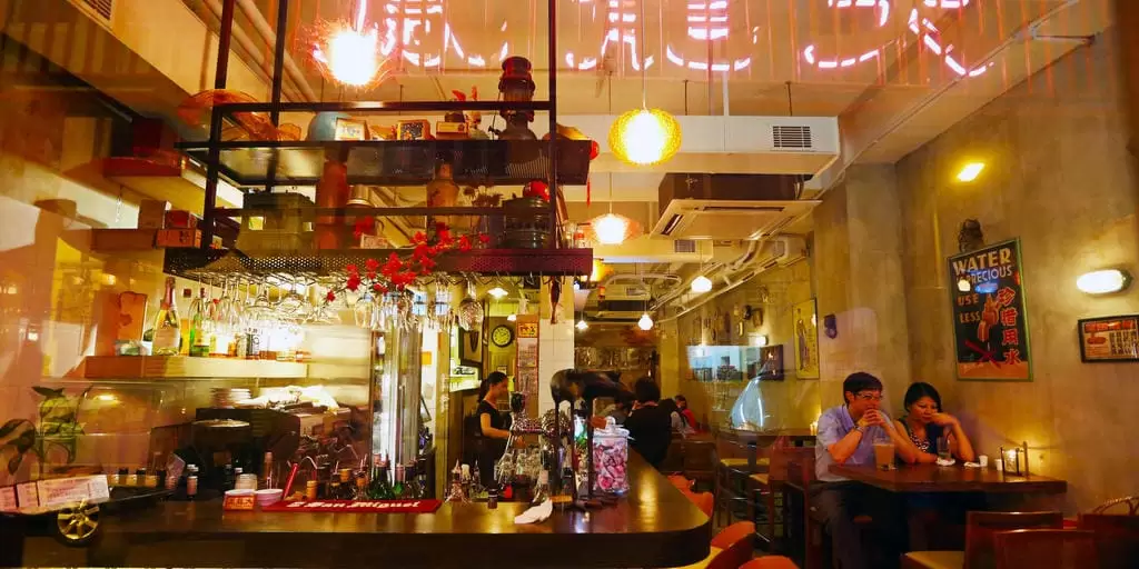 People sitting at tables inside Tai Fungg Lung alongside a central bar