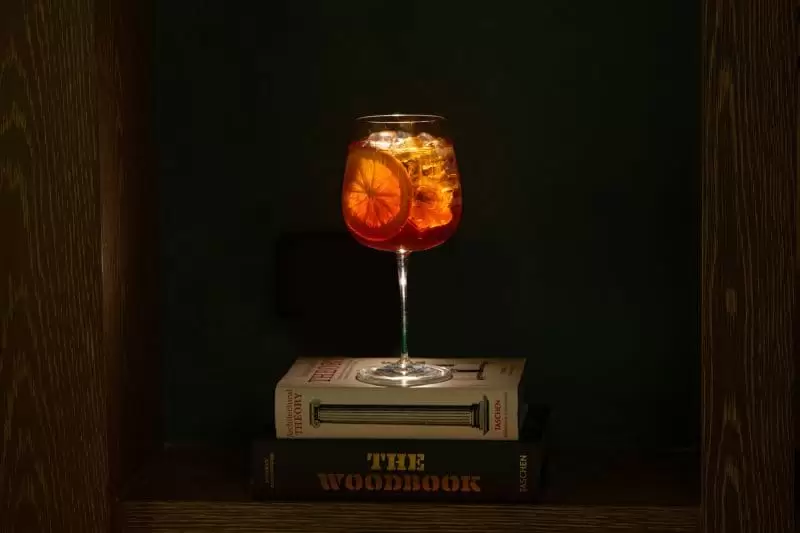 An Aperol Spritz on top of a book in the decor of Lucciola