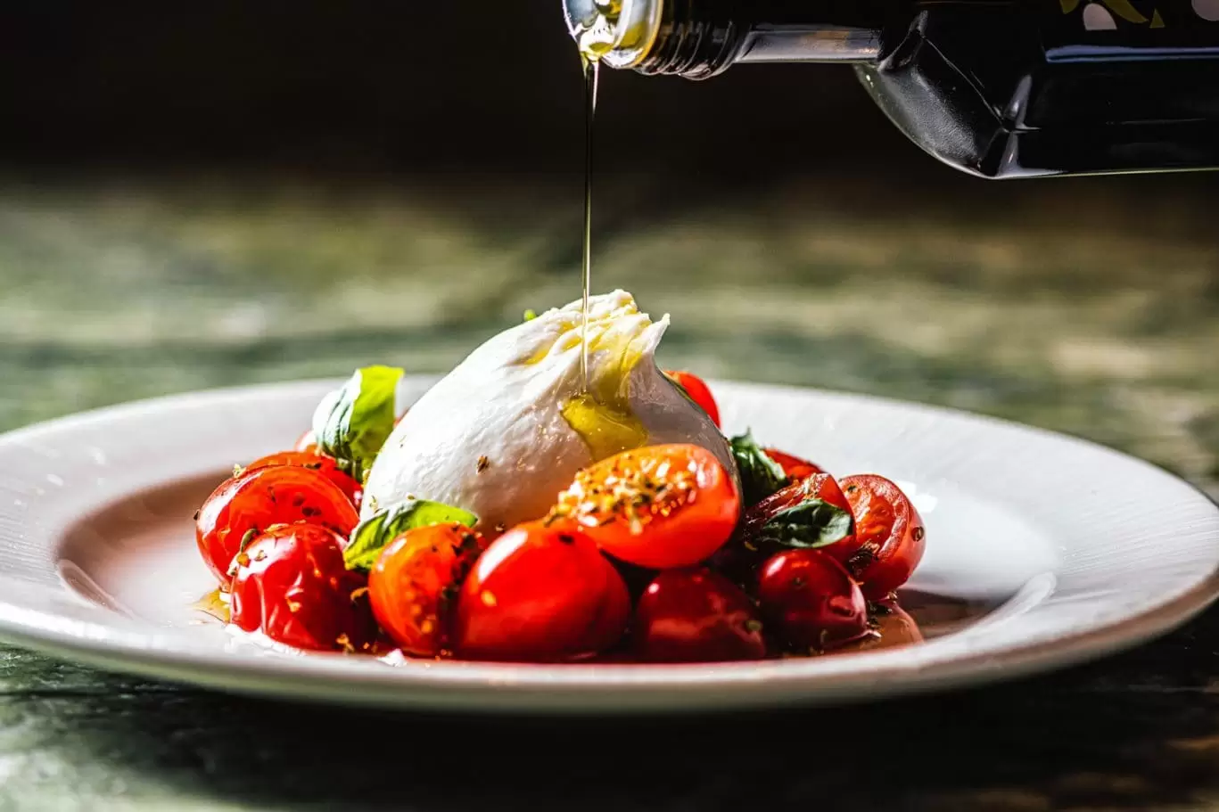 Burrata being drizzled with oil at Lucciola