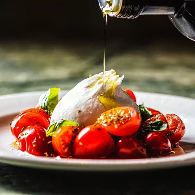 Burrata being drizzled with oil at Lucciola