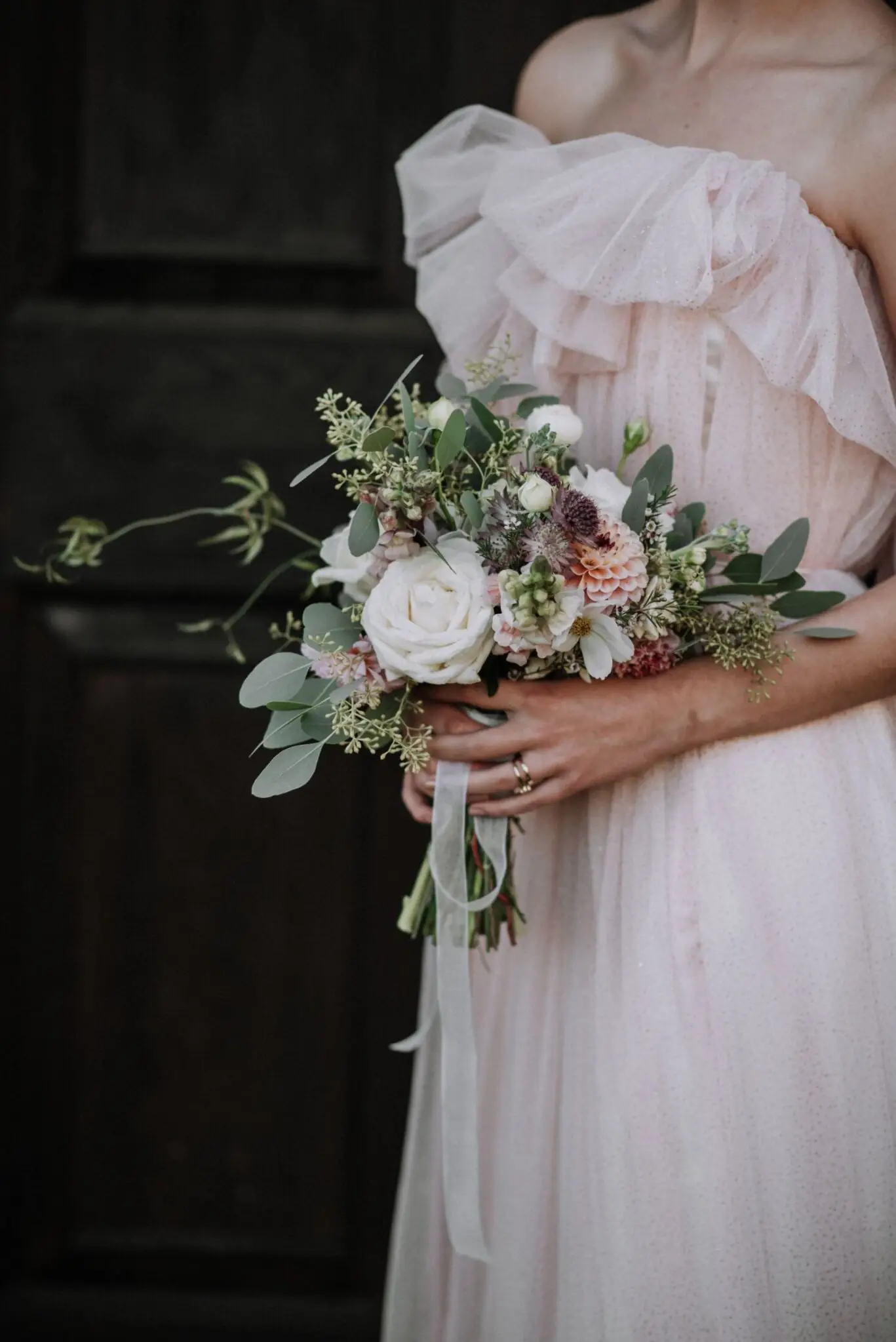vertical-shot-bride-wearing-wedding-dress-holding-flower-bouquet (1)