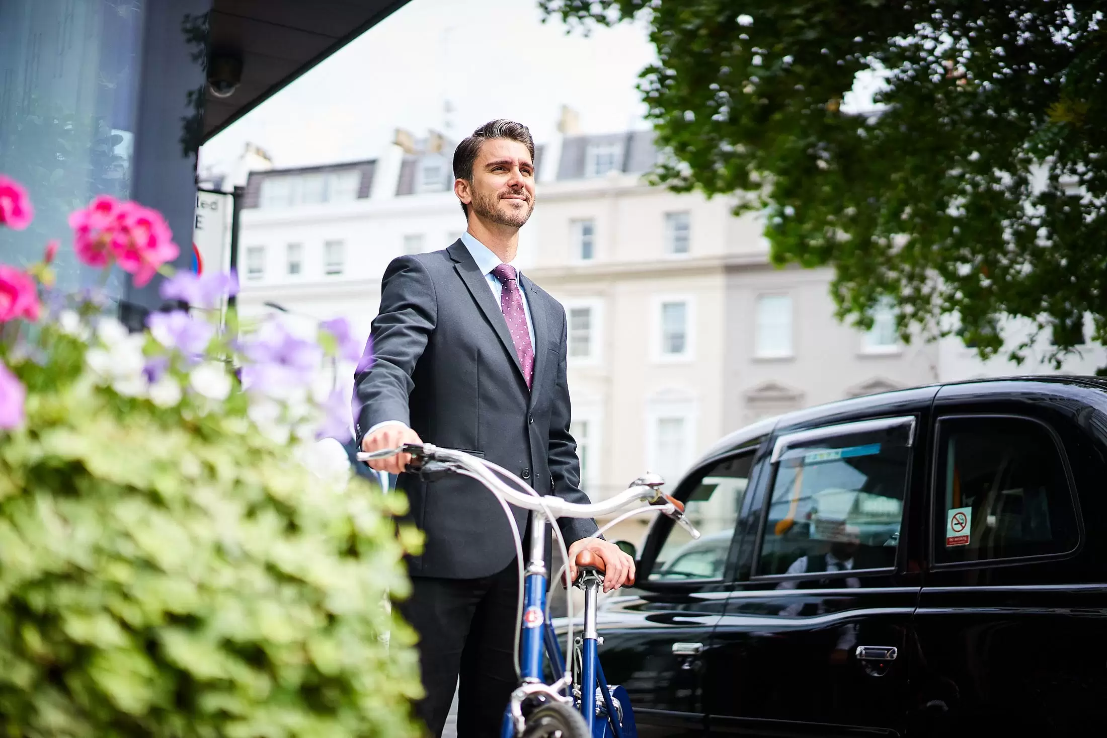 A Hari employee holding a bike outside the hotel