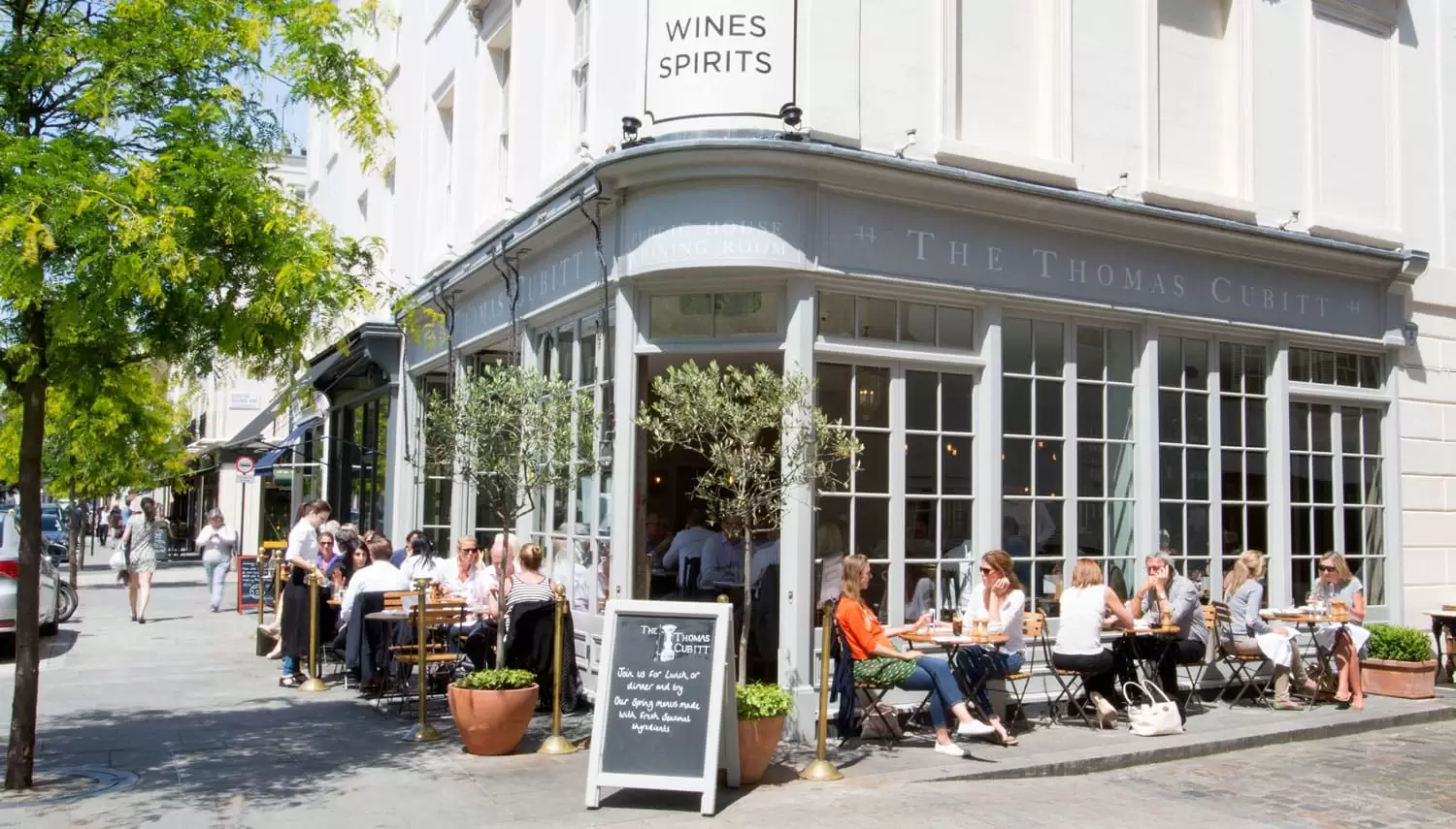 People sat on the chairs and tables outside The Thomas Cubitt pub in Belgravia